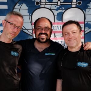 Martin, Jonathan Venn, and Gary in Blue Ribbon Dive Resort shirts in front of a TDI banner — Gary was the first ANDP Instructor certified by Jon as an SDI/TDI Instructor Trainer.