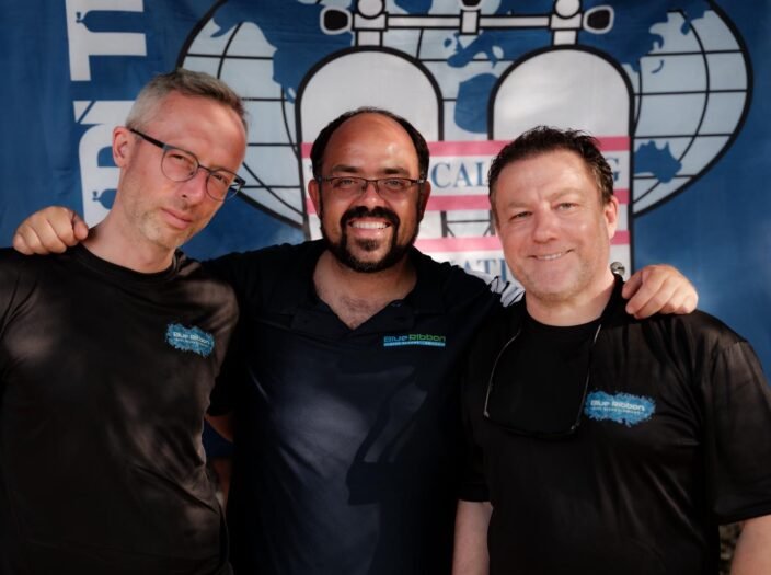 Martin, Jonathan Venn, and Gary in Blue Ribbon Dive Resort shirts in front of a TDI banner — Gary was the first ANDP Instructor certified by Jon as an SDI/TDI Instructor Trainer.