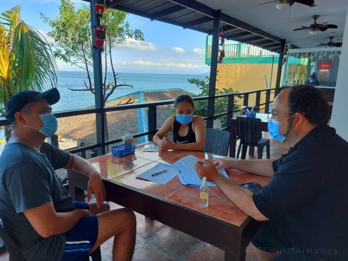 Jonathan Venn teaching a PADI dive course during the pandemic at Blue Ribbon Dive Resort in Anilao — instructor and students wearing facemasks, hand sanitiser on the table.