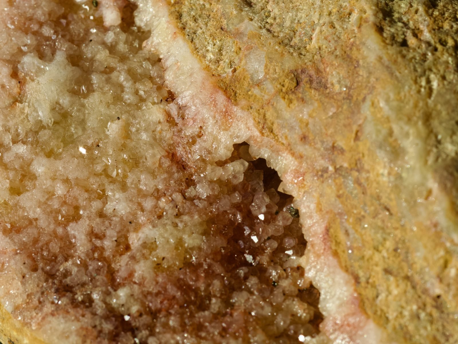 Druzy crystal cavity with pink and amber formations